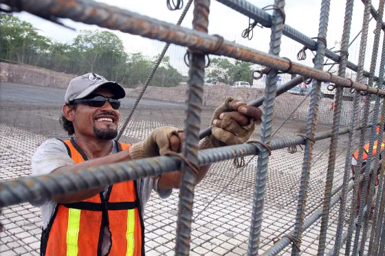 A worker assembling rebar at a construction site