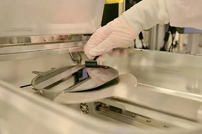 A semiconductor wafer being removed from processing equipment